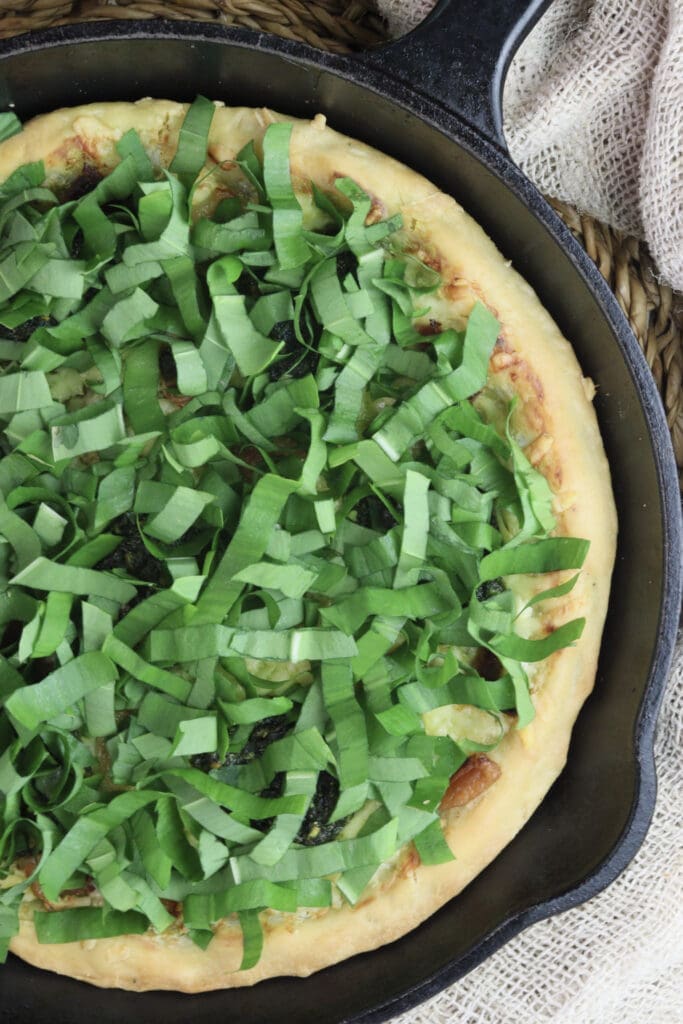 image of topping the pizza with fresh wild garlic leaves